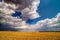 Clouds passing above rural fields.