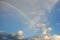 clouds with a rainbow. Multicoloured curved strip in the firmament, as a consequence of the refraction of sunlight in raindrops.