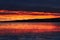 Clouds reflecting an early morning sunrise off of the frozen lake