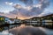 Clouds start to turn pink reflecting in the still water of Tarbert Harbour with the painted houses on Barmore Rd Scotland