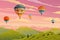 Clouds and striped hot air balloons against cloudy sky fly over mountains. Hot air balloon festival