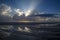 Clouds and sun reflected in tidal pool