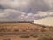 Clouds in Texas with building and doppler weather tower with brush from train