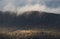 Clouds touching the green mountain