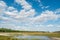 Cloudscape blue sky river lake forest sand beach daylight landscape