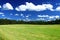 Cloudscape over green field