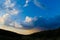 Cloudscape over silhouetted hills