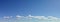 Cloudscape panorama of deep blue sky, clouds on horizon