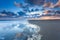 Cloudscape reflected in sea at sunrise