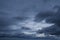 Cloudscape: a small clear blue part of the sky and dark gray stormy clouds