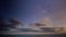 Cloudscape at sunset. The sky is gradually filled by colorful clouds. Panoramic view on a calm sea at golden hour. Timelapse scene