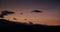Cloudscape timelapse at sunset, clouds arising over mountain silhouette