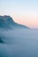 Cloudy alpine landscape with mountain range silhouette during sunset