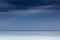 Cloudy blue minimalist seascape. Deserted space. Horizon line.