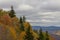 Cloudy day with view of Blue Ridge, evergreens and autumn leaves on foreground slope