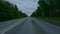 Cloudy evening skies over the interregional highway. On both sides of the road grow dense trees and shrubs. Travel by