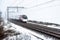 Cloudy foggy winter day view of Train on UK Railroad in England. Emma storm railway landscape.