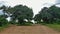 Cloudy landscape. The brown dirt road divides into two branches, tire marks on the dust.