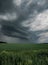 Cloudy landscape of a field with green grass. Dramatic threatening weather before storm, weather and harvest