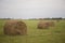 Cloudy landscape of meadows, which are mown haystacks.