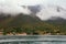 Cloudy Mediterranean landscape on rainy spring day. Clouds formation. Village at foot of mountain. Montenegro, Kotor Bay