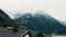 Cloudy rainy Alps mountains view from wooden balcony