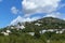 Cloudy rocky mountain with grass, trees and houses. Ibiza island, Spain