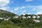 Cloudy rocky mountain with grass, trees and houses. Ibiza island, Spain