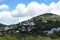 Cloudy rocky mountain with grass, trees and houses. Ibiza island, Spain