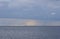 Cloudy seascape with sailing yacht and floating lighthouse