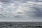 Cloudy seascape with a ship on the horizon