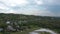 Cloudy sky over distant city. White clouds floating on blue sky over buildings of distant city and hilly outskirts