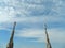 Cloudy sky over the Milan Duomo and it\'s two spires with statues