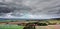 Cloudy sky over small village in the slightly hilly landscape with fields and meadows in Germany, aerial photo