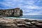 Cloudy sky over the turquoise sea and ancient basalt cliffs