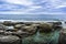 Cloudy sky over the turquoise sea and ancient basalt cliffs