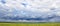 Cloudy sky before the rain over the horizon field of ripening barley