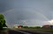 Cloudy sky with rainbow, over motorway