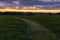 cloudy sunset over an empty green field