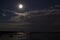 Cloudy weather in summer, moon in the night sky above lake, in R