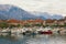 Cloudy winter day. Small marina for fishing boats at foot of mountains. Montenegro, Tivat city