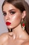 Clouse up portrait of a beautiful girl with a professional make up, bright red lips, ethnic earrings, perfect skin