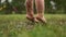 Clouse up portrait of toddlers bare feet, a child jumping in the grass through a puddle, a happy childhood, have fun. A