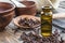 Clove essential oil in a dark glass bottle and dry clove spice on old wooden boards