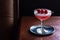 Clover Club Cocktail with Raspberries in Dark Bar