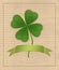 Clover with four leaves on cardboard