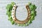 Clover leaves and horseshoe on table, flat lay. St. Patrick`s Day celebration