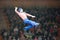 A clown acrobat performs with a number in front of the public.