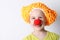 Clown baby girl with a red nose in a funny cap