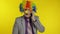 Clown businessman entrepreneur boss talking on mobile phone. Yellow background